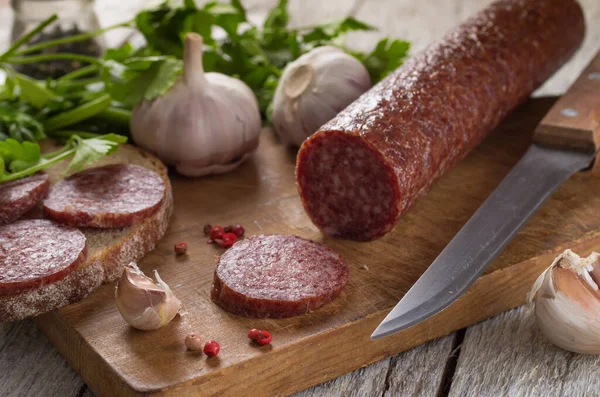 Salami and bread on a wooden board — Stock Photo, Image