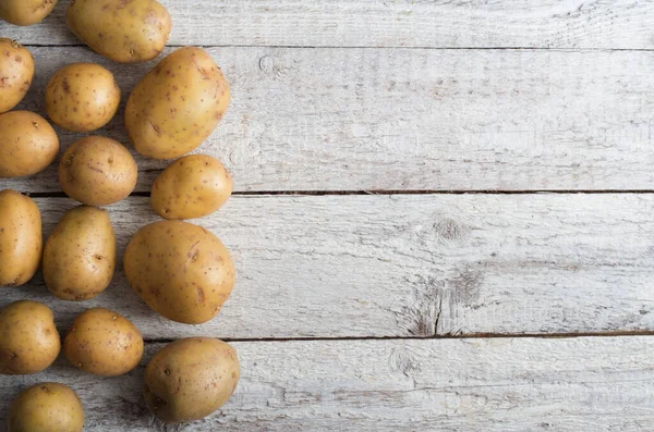 Świeżych ziemniaków na starym drewnianym stole — Zdjęcie stockowe