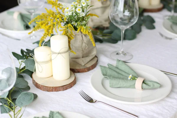 野生花桌装饰 白色地方的绿色亚麻餐巾和白色亚麻桌布 免版税图库照片