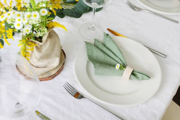 ワイルドフラワーテーブルの装飾 白い場所に緑のリネンナプキンと白いリネンテーブルクロス ロイヤリティフリーのストック画像