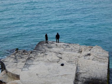 Hazar Denizi kıyısında iki kişi.