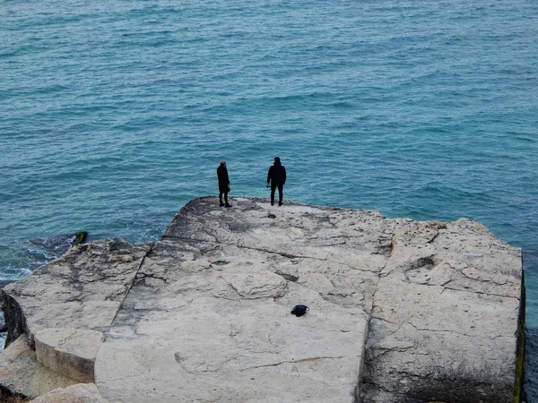 Hazar Denizi kıyısında iki kişi.