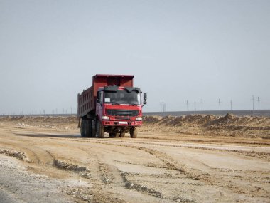 Yeni bir yol döşeme kırmızı Damper çölde. Kazakistan.