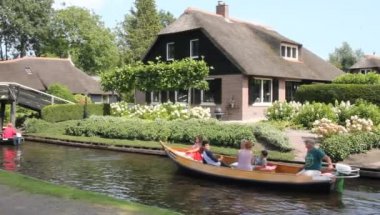 Giethoorn, Hollanda - 23 Ağustos 2017: Giethoorn 'da bir kanalda bilinmeyen ziyaretçiler. Şehir 