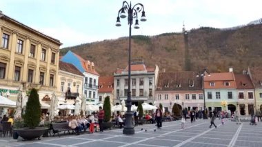 Brasov, Romanya - 29 Ekim, 2018: (Piaa Sfatului'deki) Belediye Meydanı'nda yürüyüş insanlar. Piyasalar, kiliseler ve restoranlar en ünlü şehir alan tutar.
