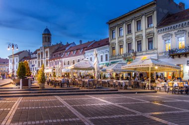Brasov, Romanya - 29 Ekim 2018: Meclis Meydanı 'nda yürüyen insanlar. En ünlü şehir alanı pazarlar, kiliseler ve restoranlardır..