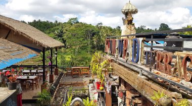 Bali, Endonezya - 28 Haziran 2019: Tegallalang'daki kafelerin arka planda pirinç terasları ile görünümü. Bölge, tarlaları, mağazaları ve barları ile ünlüdür..