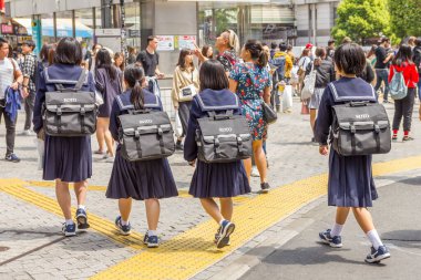 Tokyo, Japonya - 21 Nisan 2019: Tokyo sokaklarında üniformalarla yürüyen öğrenciler. Japonya 'da, üniformalar özgürlüğün sembolüdür, giyenlerin arzularını ve isteklerini yansıtır..