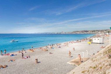 Nice, Fransa - 20 Haziran 2016: Turistler sahilde güzel havanın tadını çıkarıyorlar. Sahil ve liman bulvarı, Promenade des Anglais, neredeyse bütün bir yıl dolu..