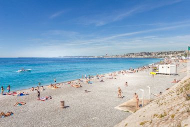 Nice, Fransa - 20 Haziran 2016: Turistler sahilde güzel havanın tadını çıkarıyorlar. Sahil ve liman bulvarı, Promenade des Anglais, neredeyse tüm yıl dolu..