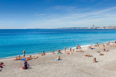 Nice, Fransa - 20 Haziran 2016: Turistler sahilde güzel havanın tadını çıkarıyorlar. Sahil ve liman bulvarı, Promenade des Anglais, neredeyse tüm yıl dolu..