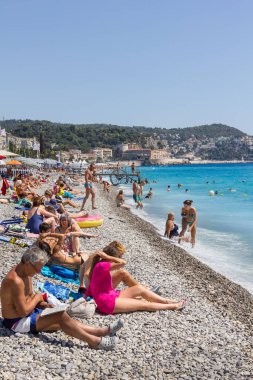 Güzel, Fransa - 23 Ağustos 2015: Turistler sahilde güzel havanın tadını çıkarıyorlar. Sahil ve liman bulvarı, Promenade des Anglais, neredeyse tüm yıl dolu..