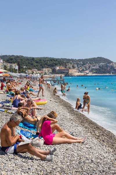 Güzel, Fransa - 23 Ağustos 2015: Turistler sahilde güzel havanın tadını çıkarıyorlar. Sahil ve liman bulvarı, Promenade des Anglais, neredeyse tüm yıl dolu..