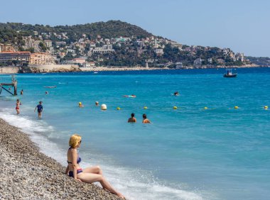 Güzel, Fransa - 23 Ağustos 2015: Turistler sahilde güzel havanın tadını çıkarıyorlar. Sahil ve liman bulvarı, Promenade des Anglais, neredeyse tüm yıl dolu..