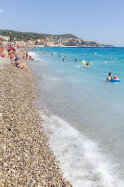 Güzel, Fransa - 23 Ağustos 2015: Turistler sahilde güzel havanın tadını çıkarıyorlar. Sahil ve liman bulvarı, Promenade des Anglais, neredeyse tüm yıl dolu..