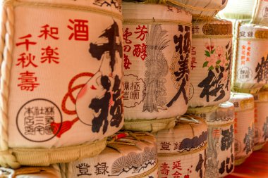 Miyajima, Japonya - 13 Nisan 2019: Sake kapları bir rafa istiflendi. Japon geleneksel alkollü içeceği mayalanan pirinçle yapılır..