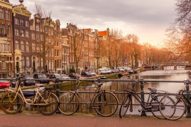 Gün batımında Amsterdam Kanalı ve bisikletler