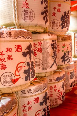 Miyajima, Japonya - 13 Nisan 2019: Sake kapları bir rafa istiflendi. Japon geleneksel alkollü içeceği mayalanan pirinçle yapılır..