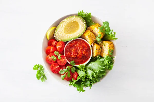 vegan buddha bowl. healthy lunch bowl with avocado, tomato, sweet corn and salsa
