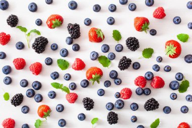 Beyaz arka planda çeşitli meyveler. yabanmersini, çilek, ahududu, böğürtlen