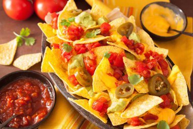 Nacho salsa, peynir, guacamole ve jalapeno ile yüklü