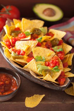 Nacho salsa, peynir, guacamole ve jalapeno ile yüklü