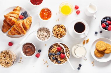 sağlıklı kahvaltı granola, berry, fındık, kruvasan, reçel, çikolata yayıldı ve kahve ile. Üstten görünüm
