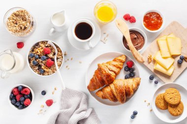 sağlıklı kahvaltı granola, berry, fındık, kruvasan, reçel, çikolata yayıldı ve kahve ile. Üstten görünüm