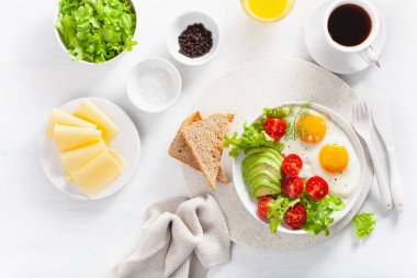 sağlıklı kahvaltı düz yatıyordu. kızarmış yumurta, avokado, domates, tost ve kahve