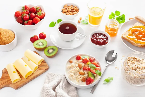 Gesundes Frühstück Mit Haferbrei Erdbeeren Nüssen Toast Marmelade Und Tee — Stockfoto