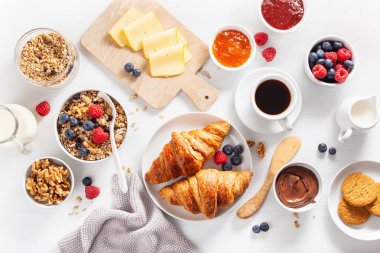 sağlıklı kahvaltı granola, berry, fındık, kruvasan, reçel, çikolata yayıldı ve kahve ile. Üstten görünüm