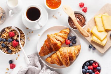 sağlıklı kahvaltı granola, berry, fındık, kruvasan, reçel, çikolata yayıldı ve kahve ile. Üstten görünüm