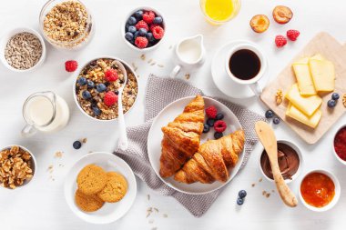 sağlıklı kahvaltı granola, berry, fındık, kruvasan, reçel, çikolata yayıldı ve kahve ile. Üstten görünüm