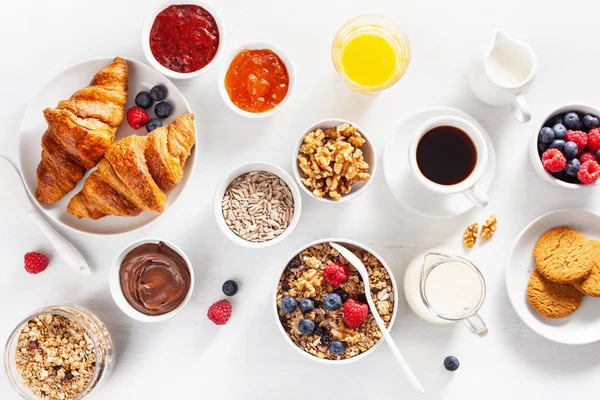 グラノーラ ベリー ナッツ クロワッサン ジャム チョコスプレッド コーヒーと健康的な朝食 トップ ビュー — ストック写真