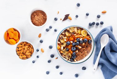 yaban mersini, fındık, muz, çikolata yulaf lapası Kurutulmuş Kayısı sağlıklı kahvaltı için. Üstten görünüm