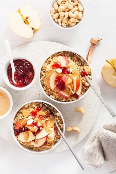 apple peanut butter quinoa bowl with jam and cashew for healthy breakfast