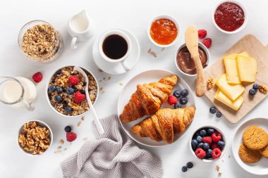 sağlıklı kahvaltı granola, berry, fındık, kruvasan, reçel, çikolata yayıldı ve kahve ile. Üstten görünüm