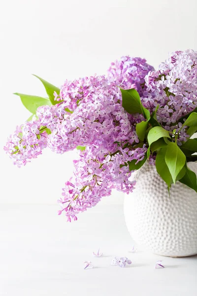 Красиві бузкові квіти у вазі на білому тлі — стокове фото