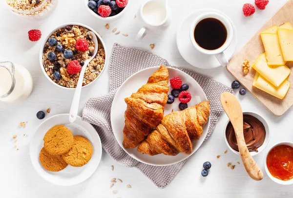 Petit déjeuner sain avec granola, baies, noix, croissant, confiture, cho — Photo