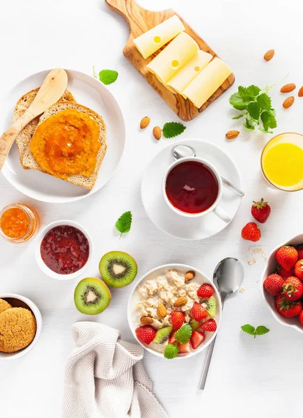 オートミールのお粥、イチゴ、ナッツ、トースト付きのヘルシーな朝食 — ストック写真