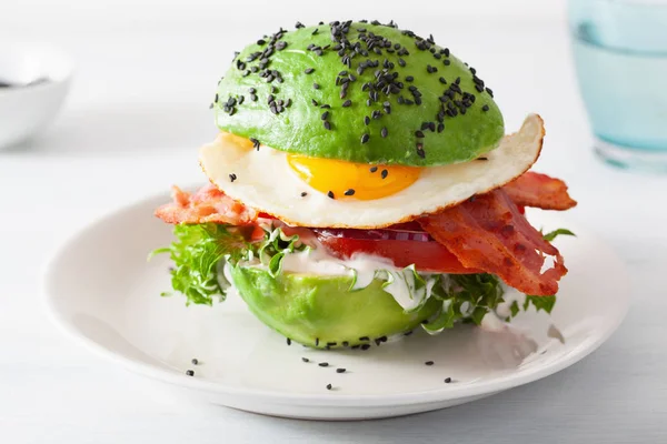 Keto paleo dieta awokado śniadanie burger z bekonem, jajko, pomidor — Zdjęcie stockowe