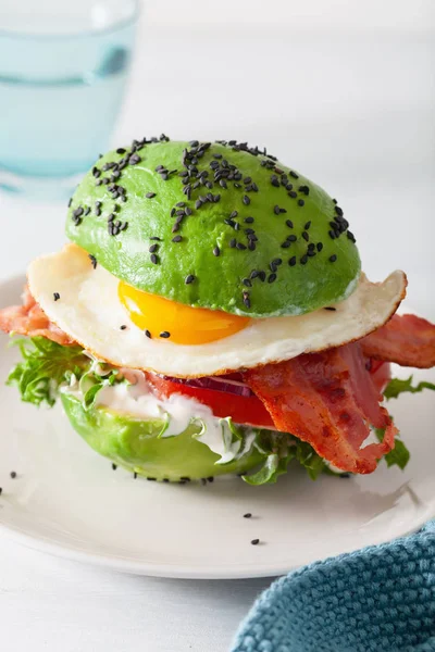 Keto paleo dieta awokado śniadanie burger z bekonem, jajko, pomidor — Zdjęcie stockowe