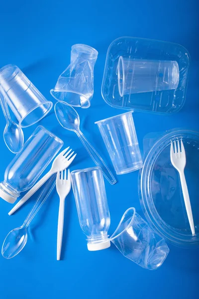 single use plastic bottles, cups, forks, spoons. concept of recy