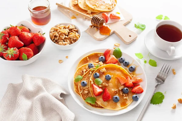 Pancake dengan madu blueberry strawberry dan kacang untuk sarapan — Stok Foto