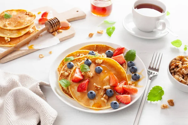 Pancake dengan madu blueberry strawberry dan kacang untuk sarapan — Stok Foto