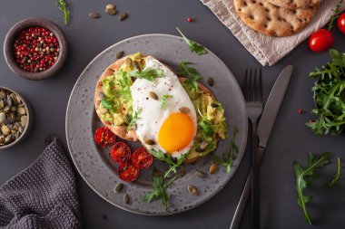 Kahvaltı avokado sandviç kızarmış yumurta ve domates ile