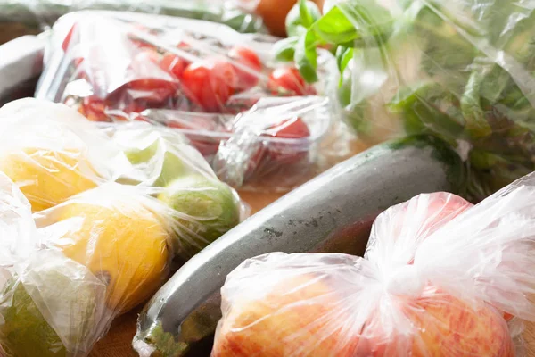 Egyszeri használatra műanyaghulladék-kibocsátás. gyümölcsök és zöldségek műanyagban — Stock Fotó