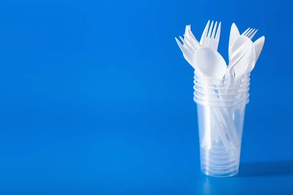 single use plastic cups, forks, spoons. concept of recycling pla