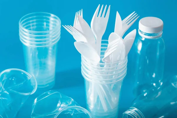 Copos de plástico de uso único, garfos, colheres. conceito de reciclagem pla — Fotografia de Stock
