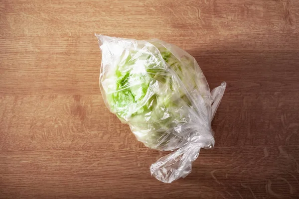 iceberg lettuce vegetable in plastic bag. single use plastic pac